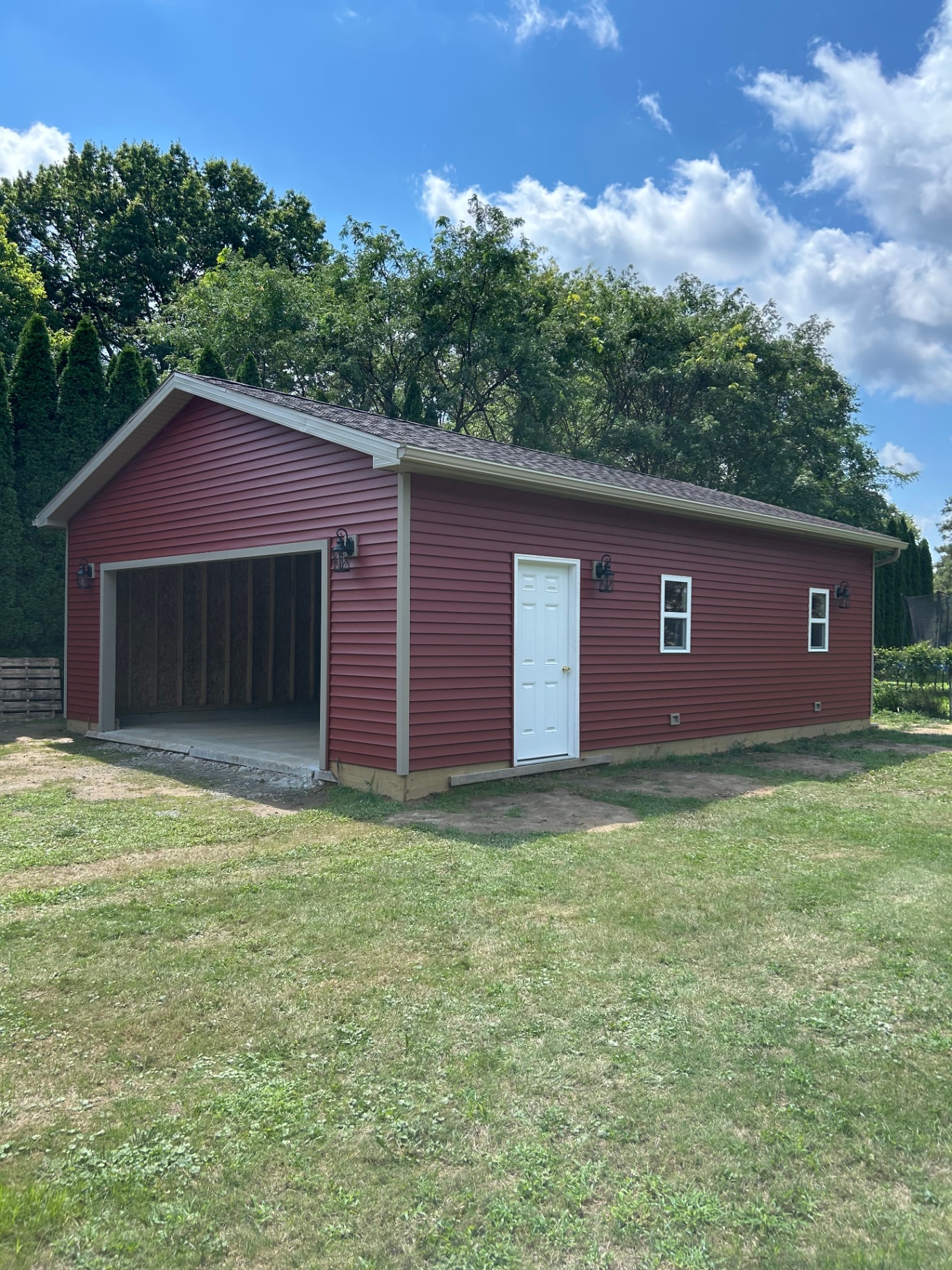 Completed red barndominium with garage and entry door built by Lou Reynolds Construction in Northeast Ohio